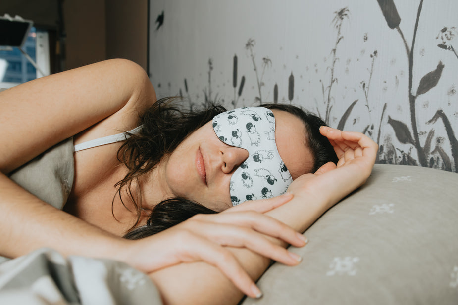 Woman sleeping peacefully with an eye mask on (tampon use during sleep discussed in blog post).